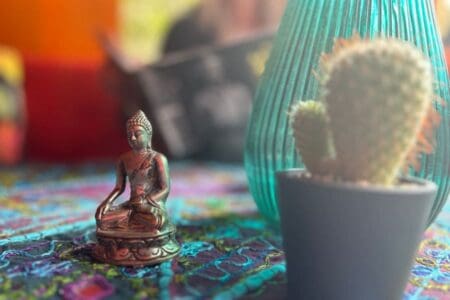 Cozy boho caravan interior with Buddha in warm red tones at Yogi Living retreat center in Skåne, Sweden.