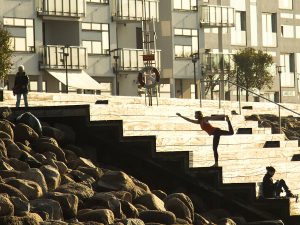 Yoga teacher doing yoga on the harbor in the city